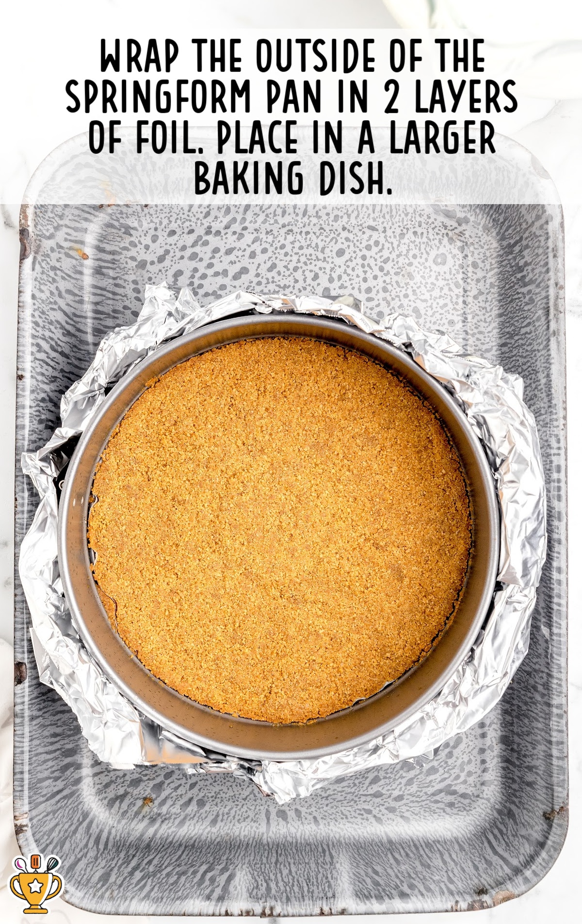 A round baking dish with Caramel Apple Cheesecake placed on another larger rectangular baking dish
