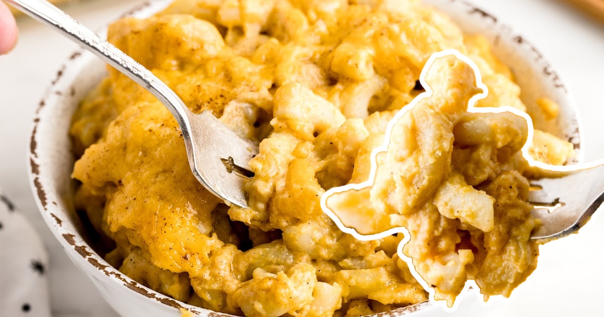 A bowl of Pumpkin Mac and Cheese with a fork in it and another fork holding some Pumpkin Mac and Cheese