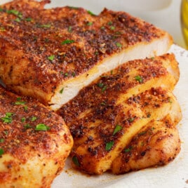 air fryer chicken breasts on a white plate, sliced.
