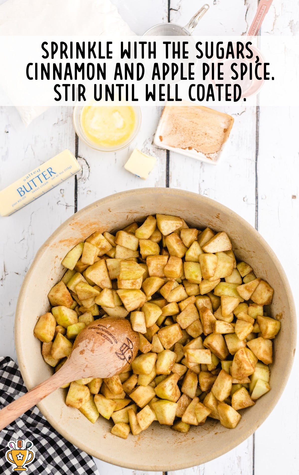 sugars, cinnamon and apple pie spice sprinkled on apples in a bowl