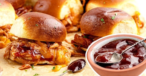 Chicken sliders with a bowl of BBQ sauce.