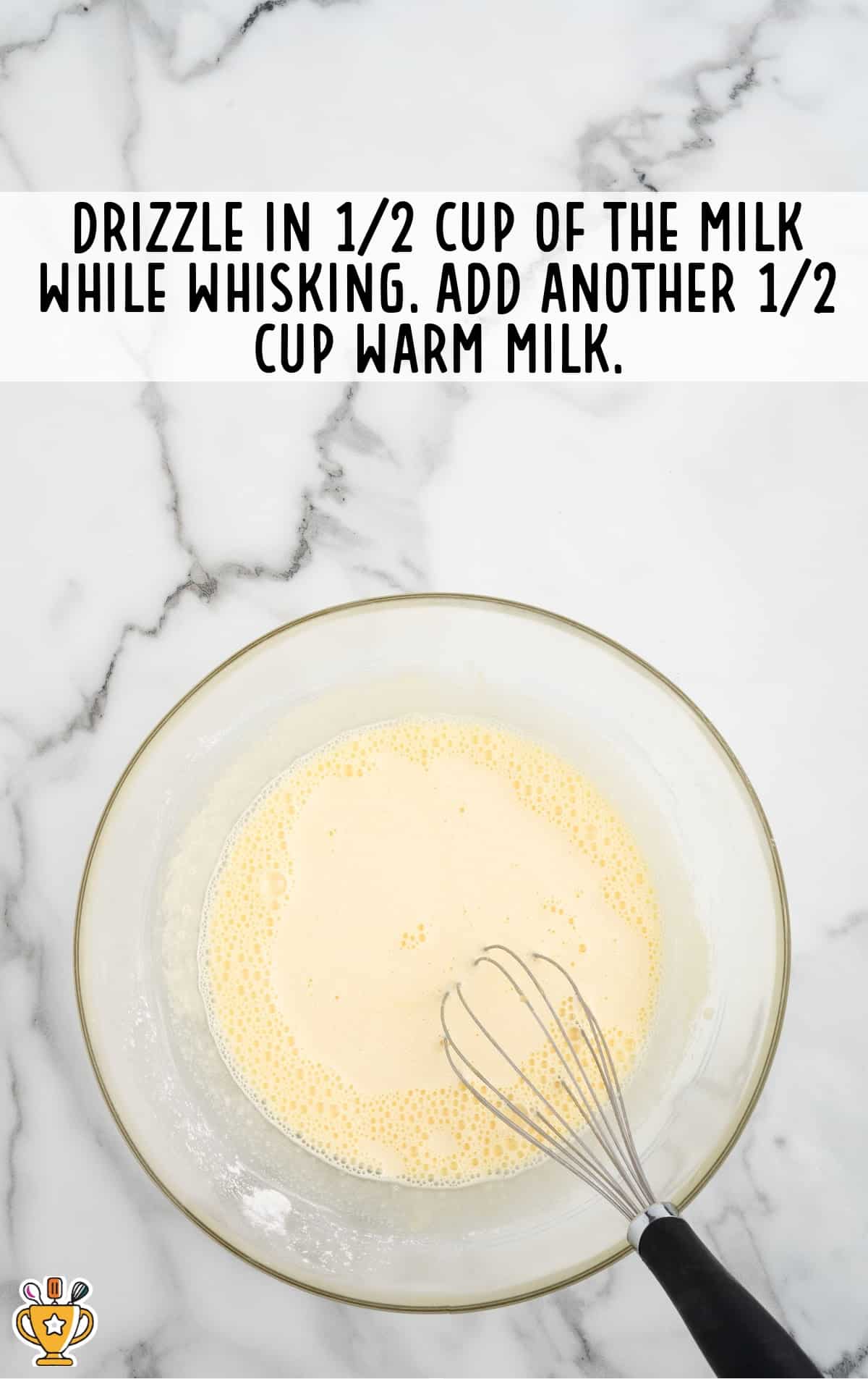 milk added in a bowl with a whisker