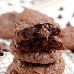 A stack of brownie mix cookies, and the top one is split in half.