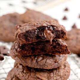 A stack of brownie mix cookies, and the top one is split in half.
