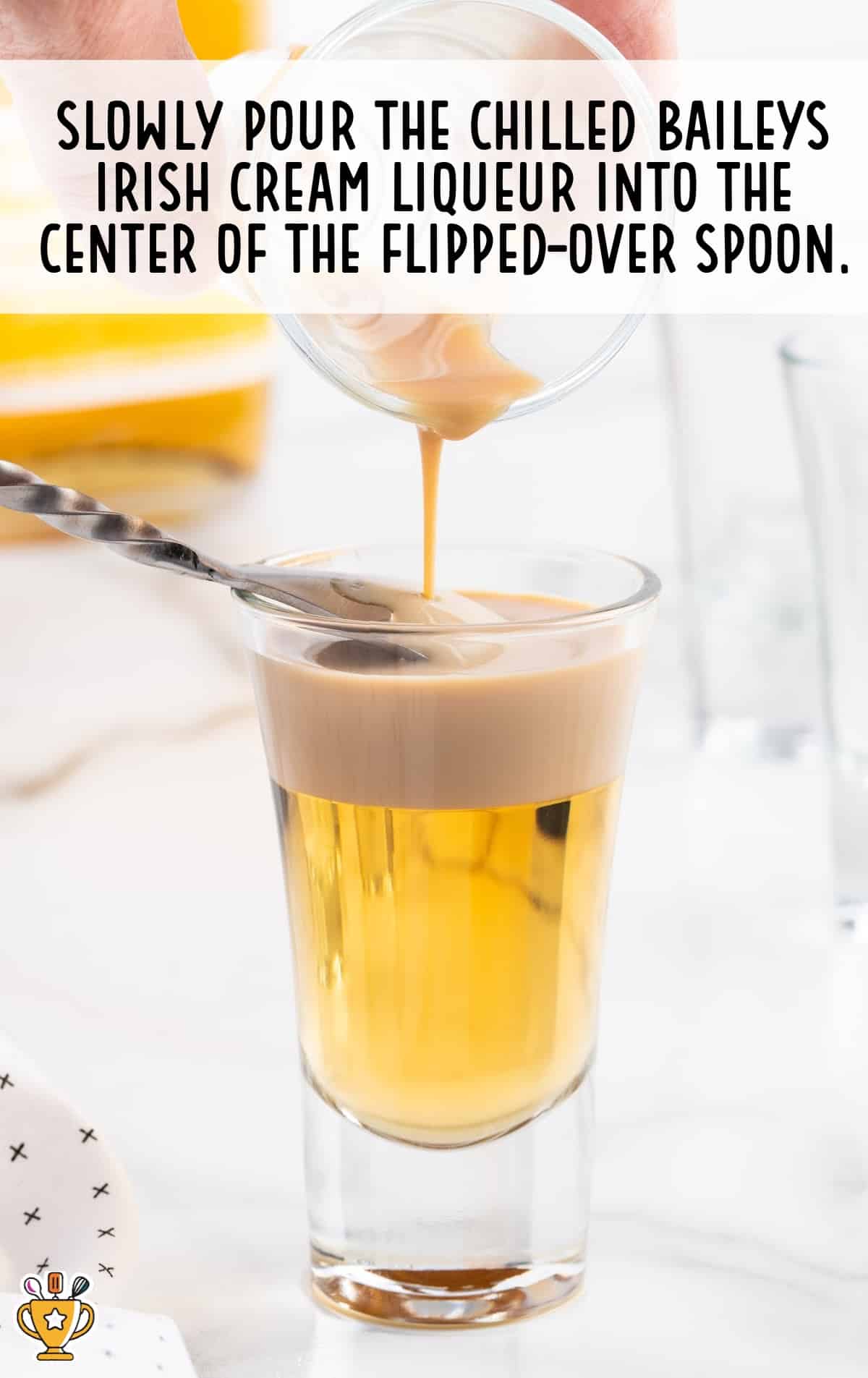 Pouring Chilled Baileys Irish Cream Liqueur into the center of the flipped-over spoon