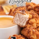 A pile of chick fil a homemade nuggets by a bowl of sauce. one is split in half.