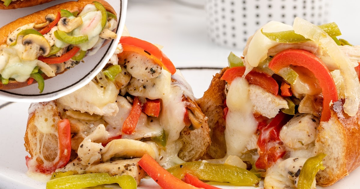 A Chicken Cheesesteak on a plate cut open.