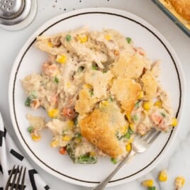an overhead view of chicken cobbler on a dinner plate with a fork