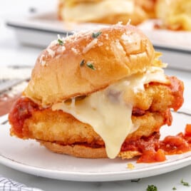 A chicken parmesan slider on a white plate.