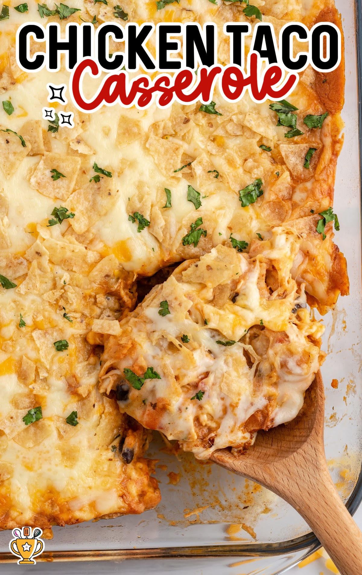 Chicken Taco Casserole in a baking pan with a wooden spoon in it