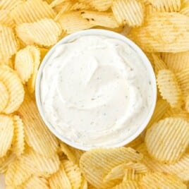 Chip Dip on a plate with some sauce in a small serving bowl