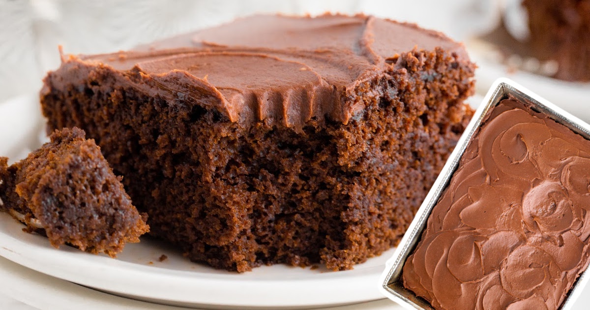 A slice of cake on a white plate next to a whole cake in a 9x13 baking pan.