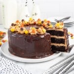 A wholeChocolate Peanut Butter Cake with a slice being lifted out.