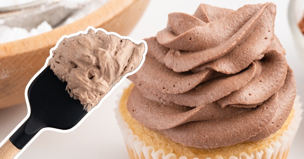 Chocolate Whipped Cream on a vanilla cupcake beside a spatula.