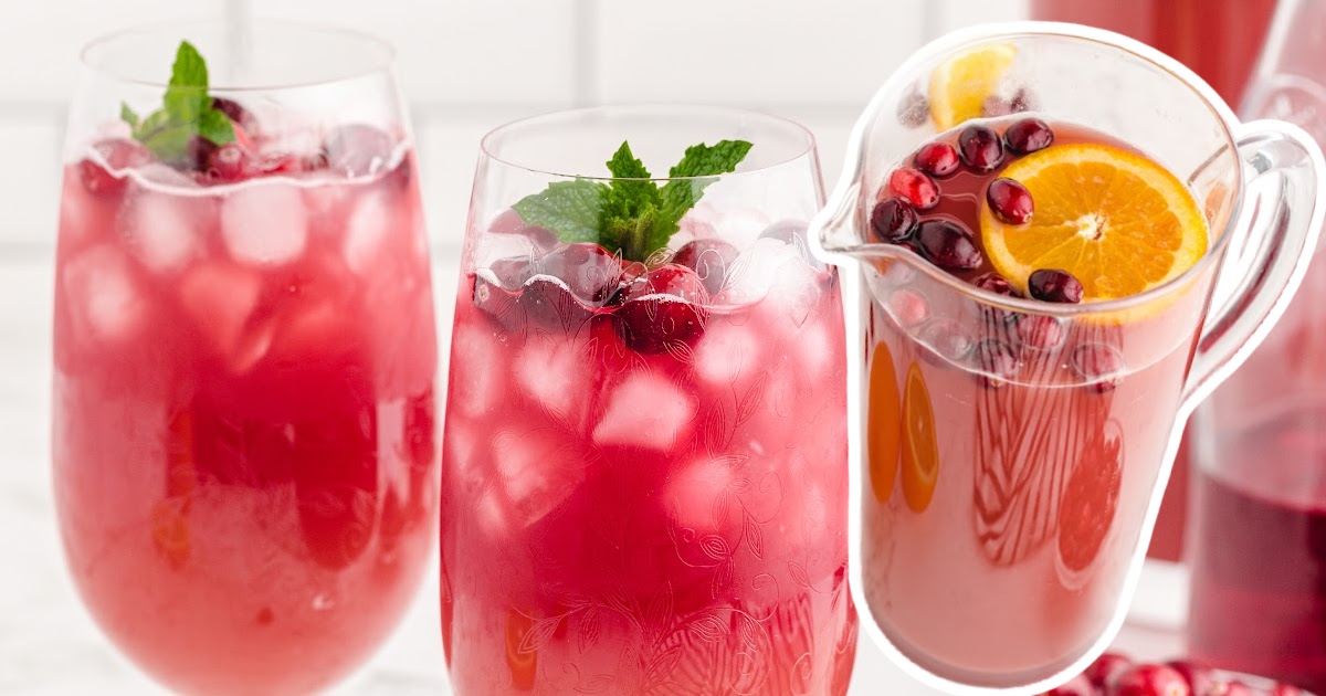 A pitcher of punch beside 2 glasses of Christmas Punch.