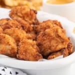 a white bowl full of copycat chick fil a nuggets.