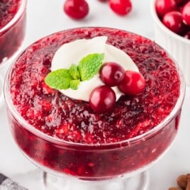 Cranberry Jello Salad in a glass, with a some cranberry on top