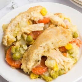 A plate of chicken pot pie with a flaky crust and lots of filling.