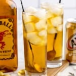 Two glasses of fireball and cream soda next to a bottle of fireball.