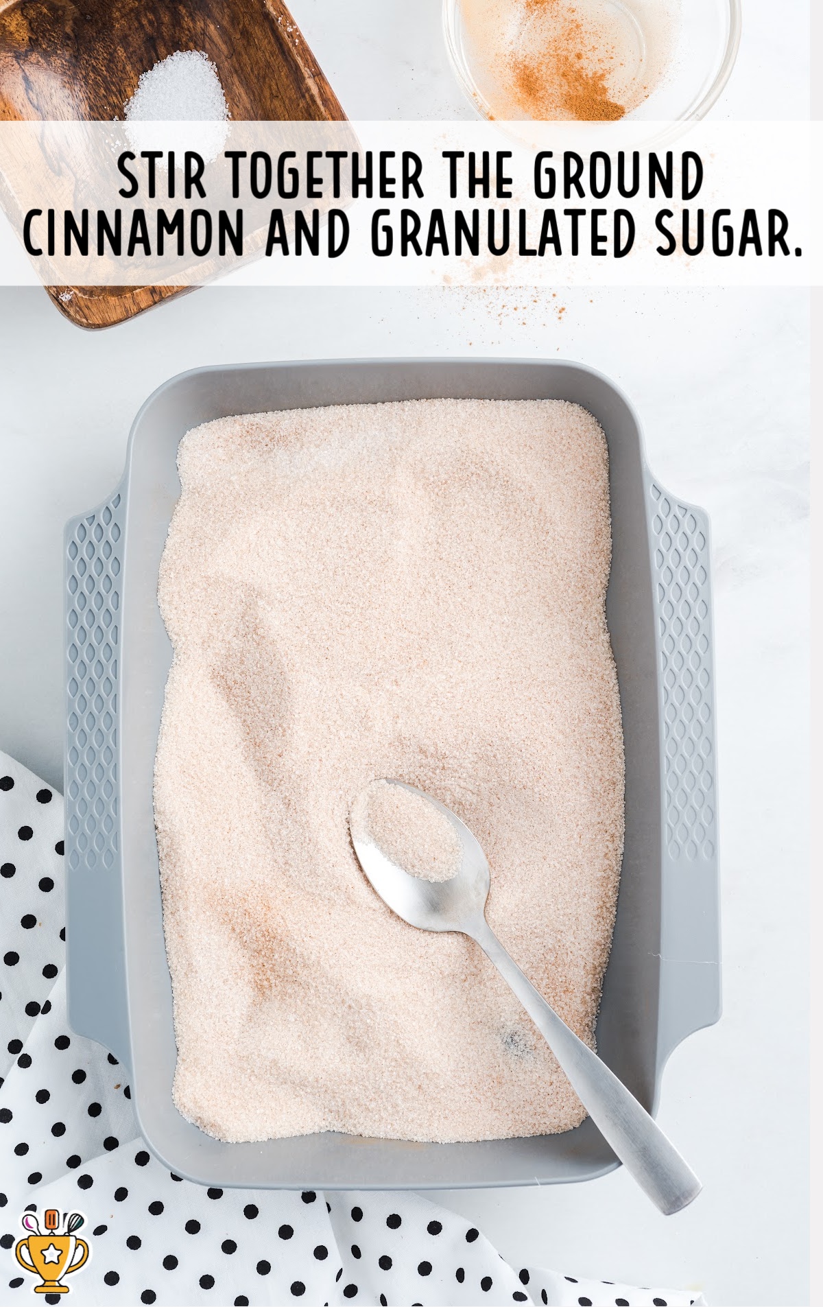 cinnamon and sugar mixed together in a container bowl with a spoon in it