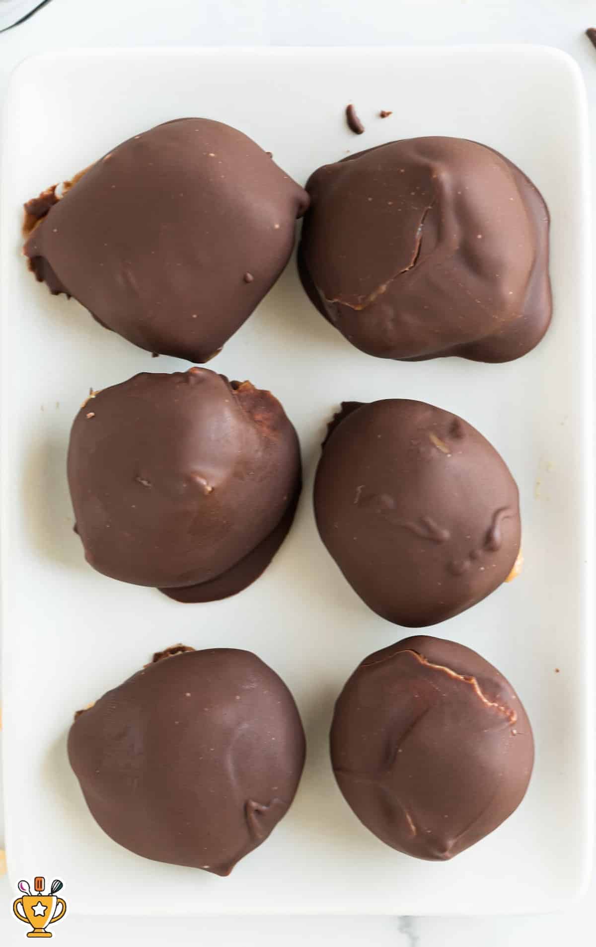 six Keto Chocolate Peanut Butter Balls on a white plate