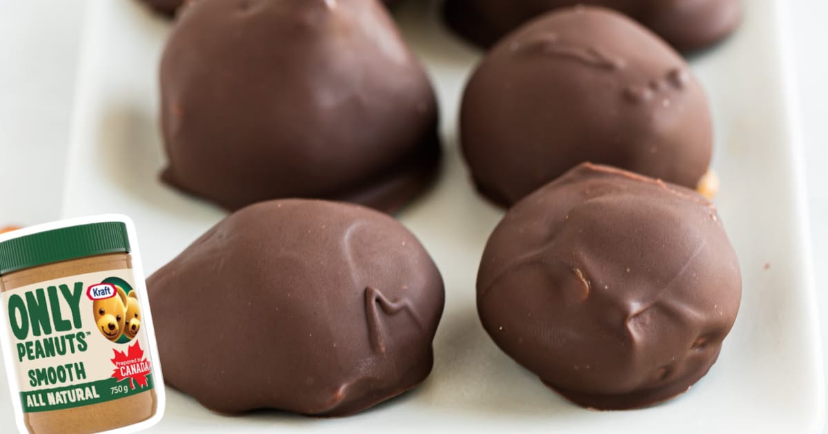 A plate of keto chocolate peanut butter balls beside a jar of peanut butter.