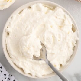 Mascarpone Frosting in a bowl with a spoon in it