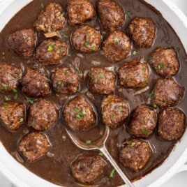 Smothered Meatballs in a pan with a spoon in it
