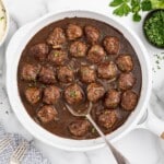 Smothered Meatballs in a pan with a spoon