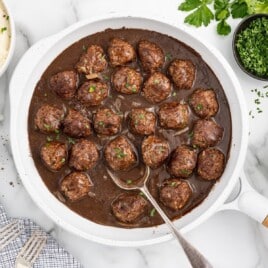 Smothered Meatballs in a pan with a spoon