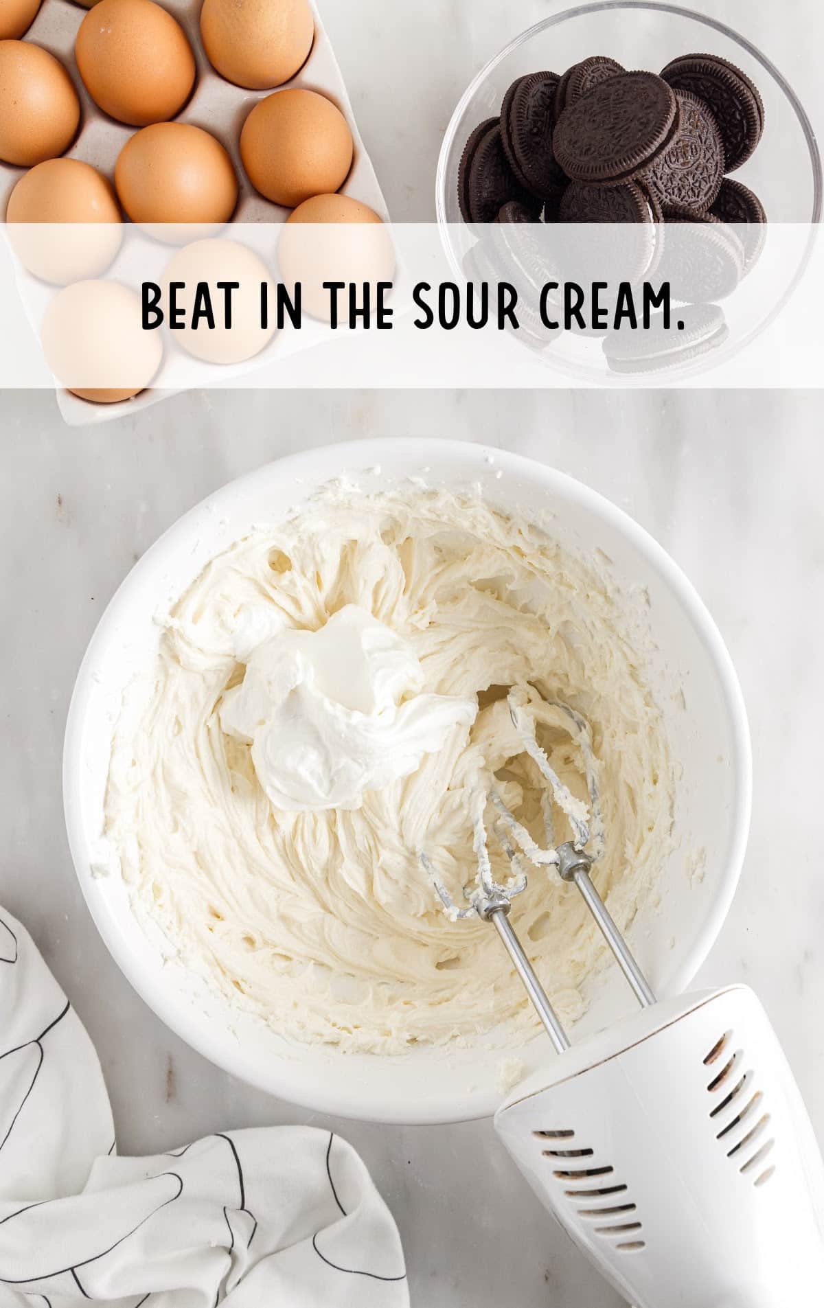 Sour cream and cream cheese in a bowl with a mixer