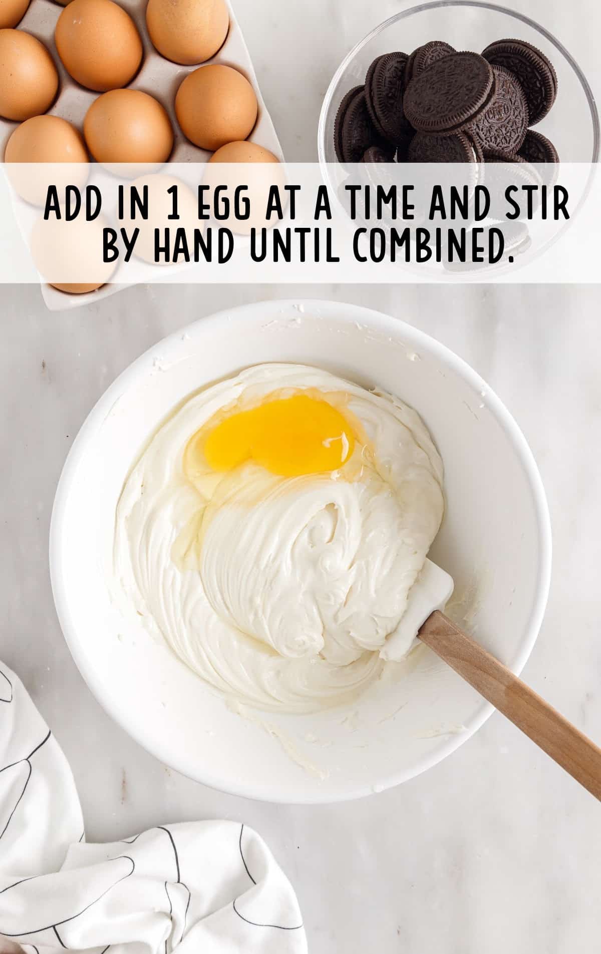 Egg added in a bowl of cream cheese