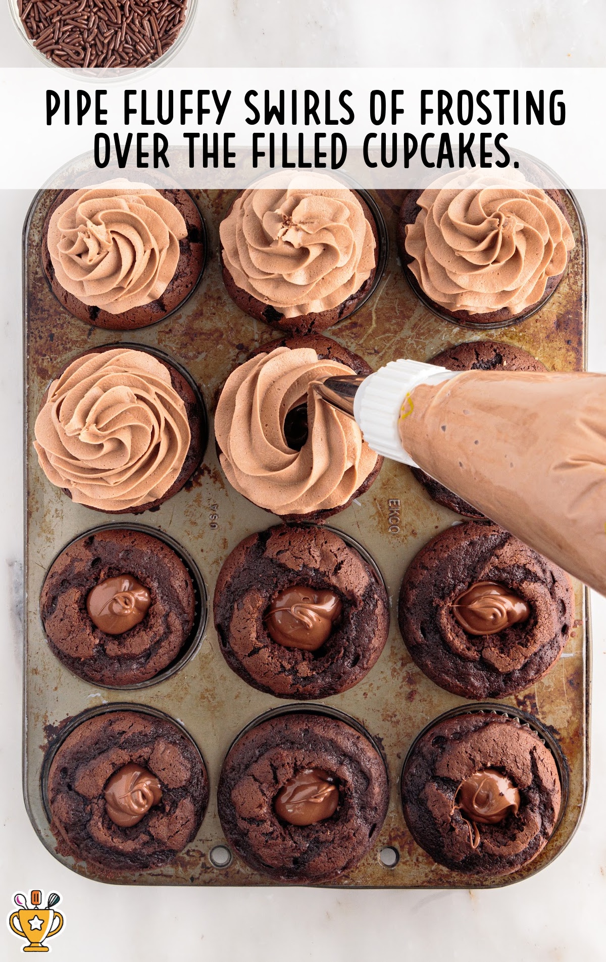 A pipe putting swirls of frosting over cupcakes
