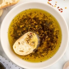 An overhead shot of a bowl of bread dip with a piece of bread in it.