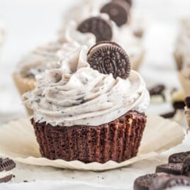 An Oreo Cupcake with cookies and cream frosting and a mini Oreo cookie.