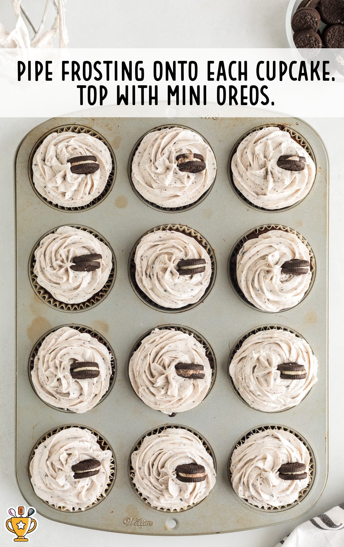 A tray of frosted cupcakes with a mini oreo decorating each one.