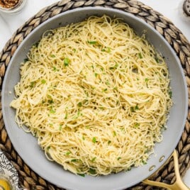 Parmesan Noodles is a skillet garnished with parsley and cheese.