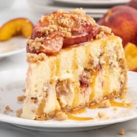 a piece of Peach Cobbler Cheesecake on a white plate