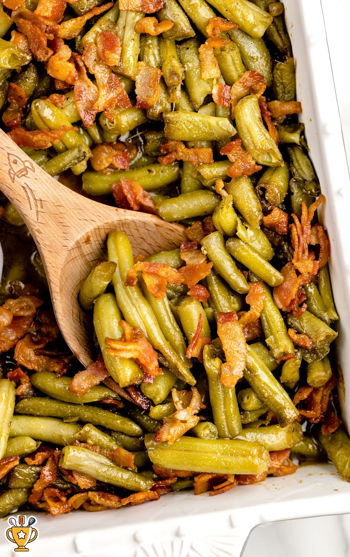 A white casserole dish full of smothered green beans.