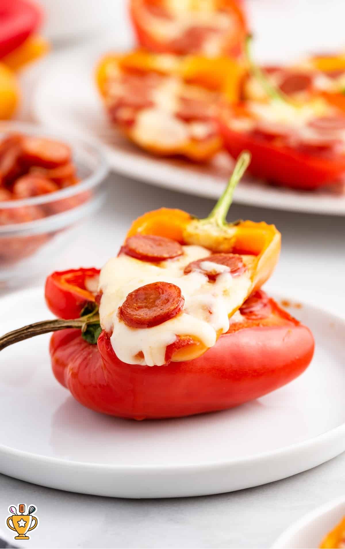 A white plate with two cooked Mini Pepper Pizzas on it.