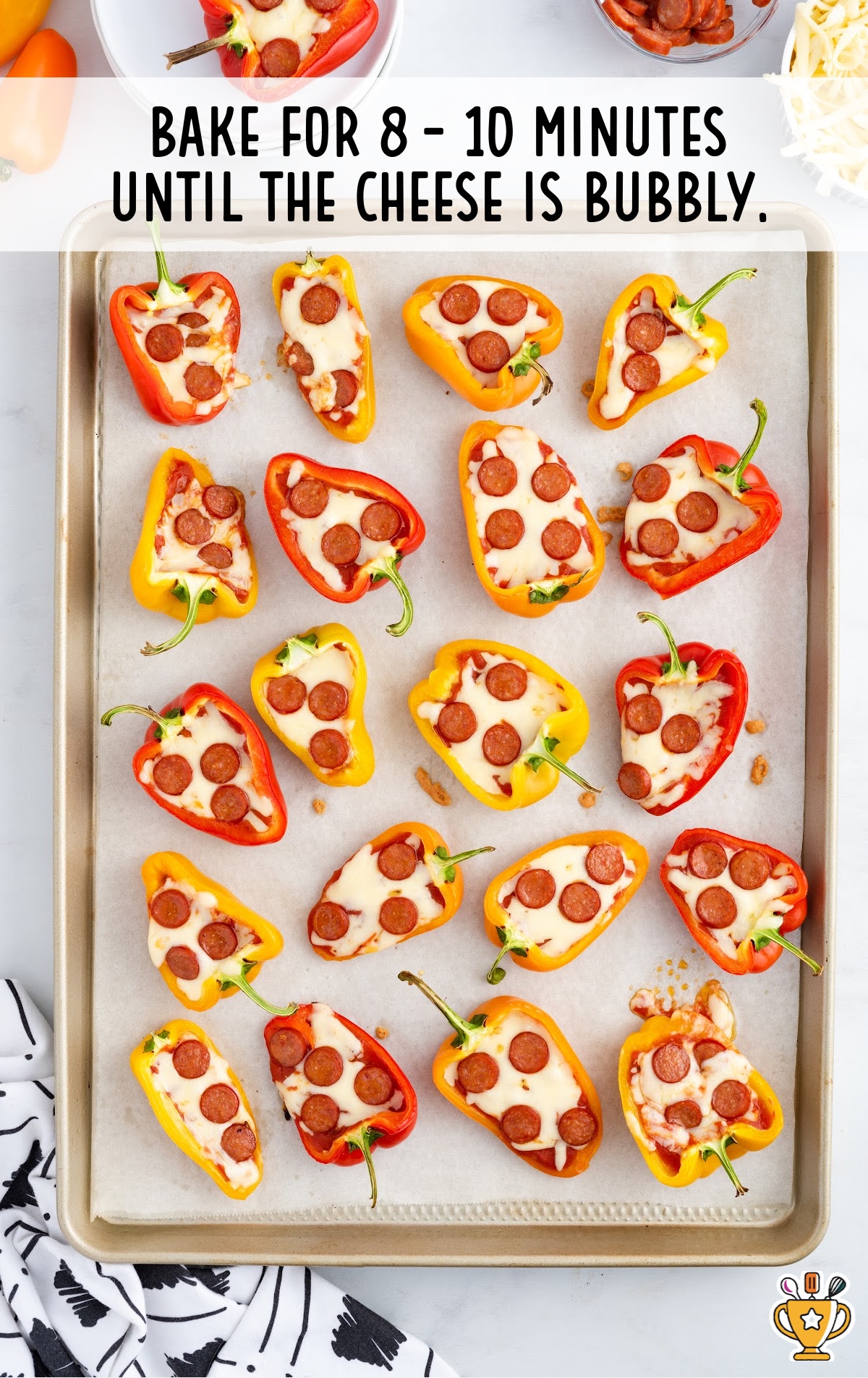 A baking pan of mini pepper pizzas after being baked.