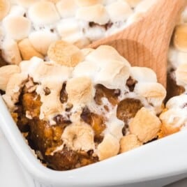 Sweet Potato Casserole in a baking tin with a wooden spoon