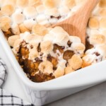 Sweet Potato Casserole in a baking tin with a wooden spoon
