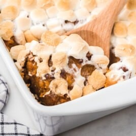 Sweet Potato Casserole in a baking tin with a wooden spoon