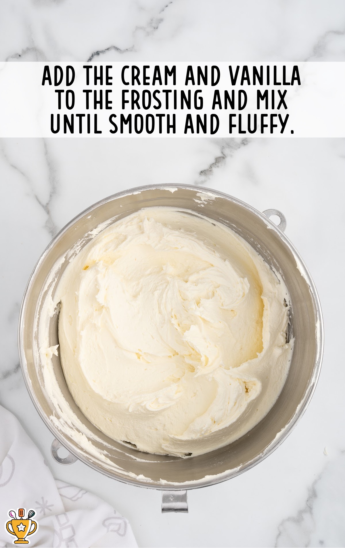 cream and vanilla added to the frosting in a bowl