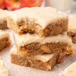 Apple brownies cut into evenly sized squares with a smooth maple glaze frosting, shown from above on a light background