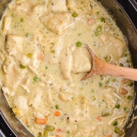 Crock Pot Chicken and Dumplings in a crockpot with a wooden spoon in it