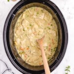 Crock Pot Chicken and Dumplings in a crockpot with a wooden spoon in it