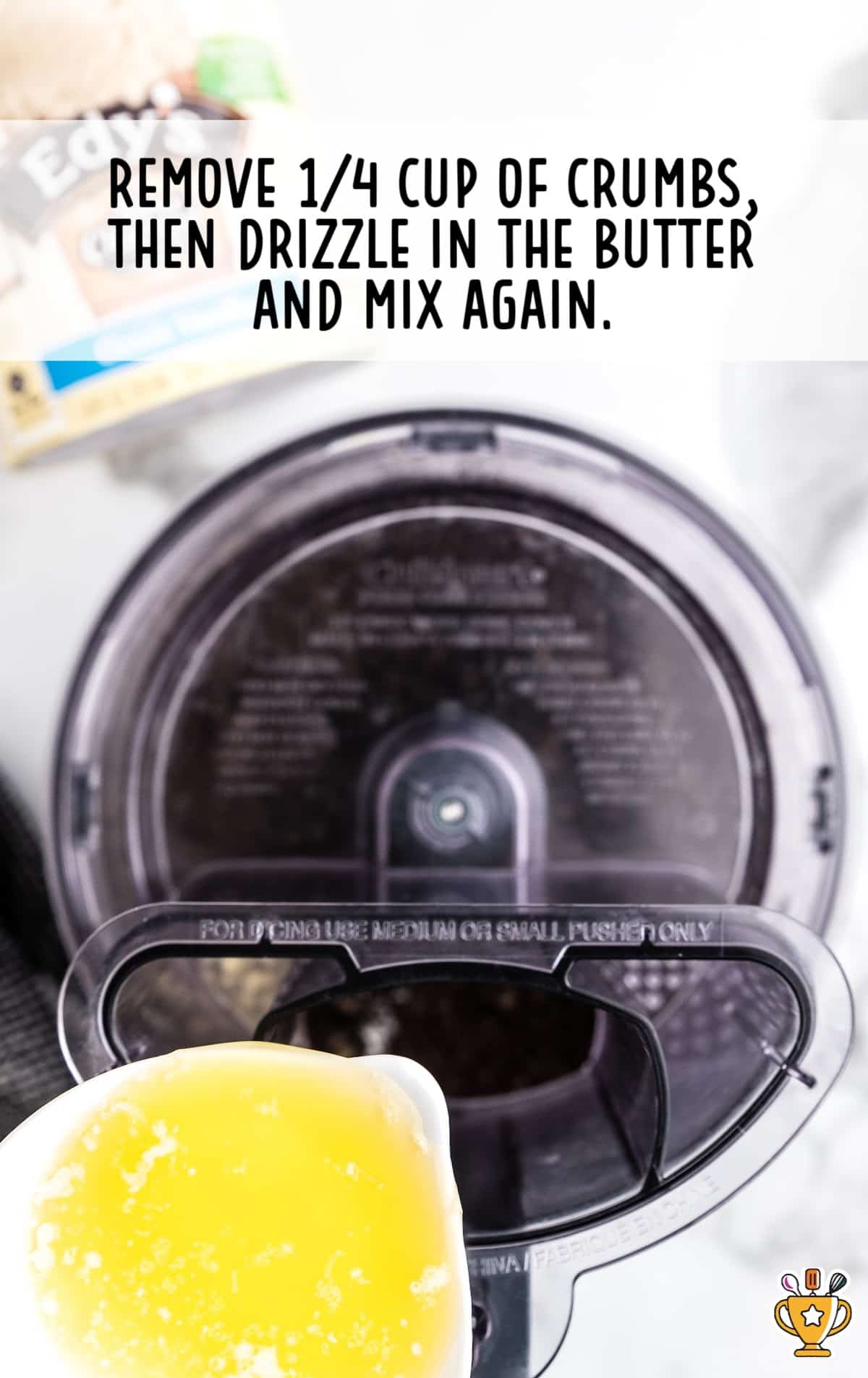 Ground cookies in a food processor with butter being poured in.
