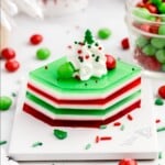 a slice of holly jolly jello shots on a plate with all the layers showing.